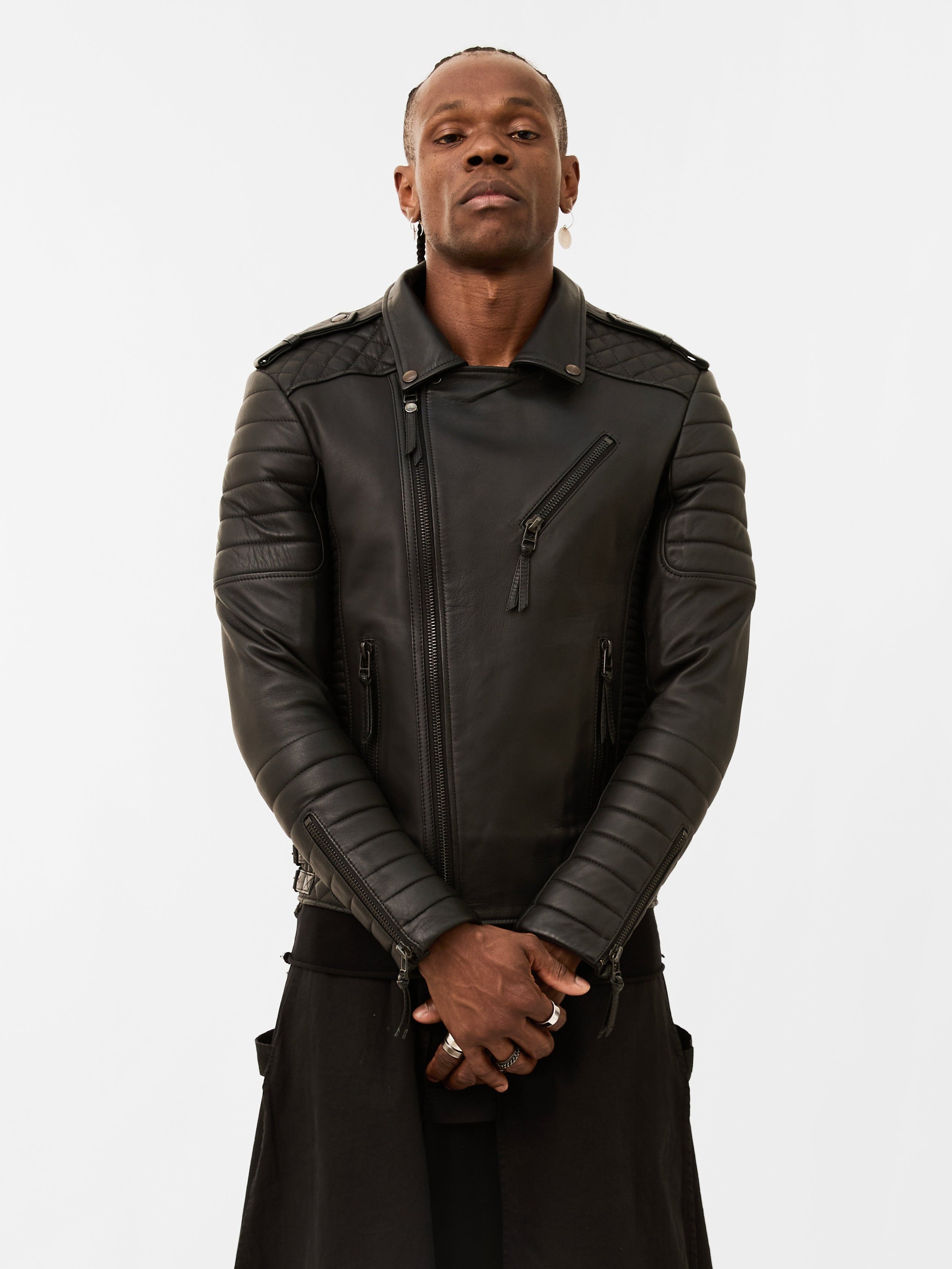 Man wearing a black leather biker jacket on a white background