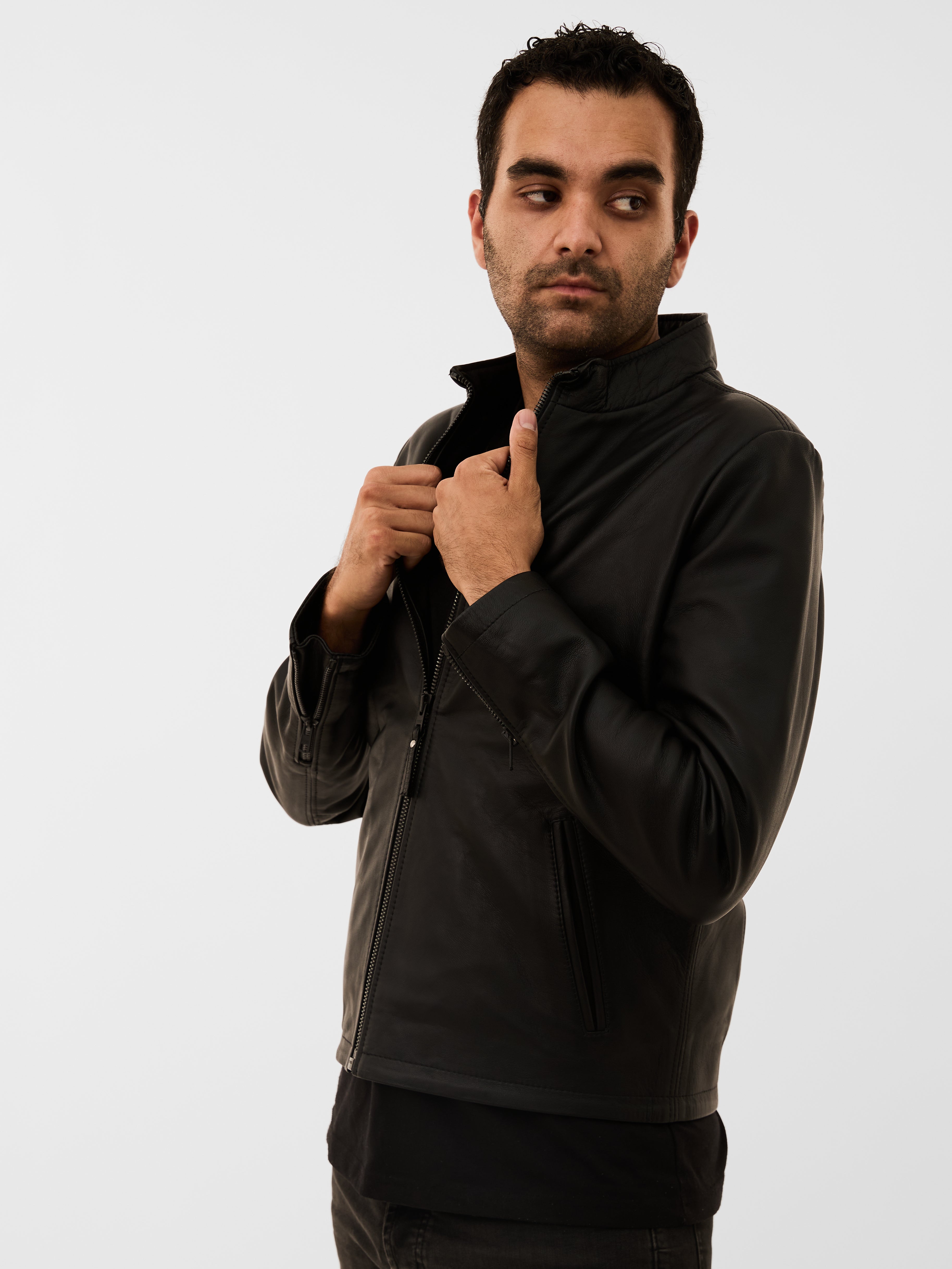 Man wearing a black jacket against a white background