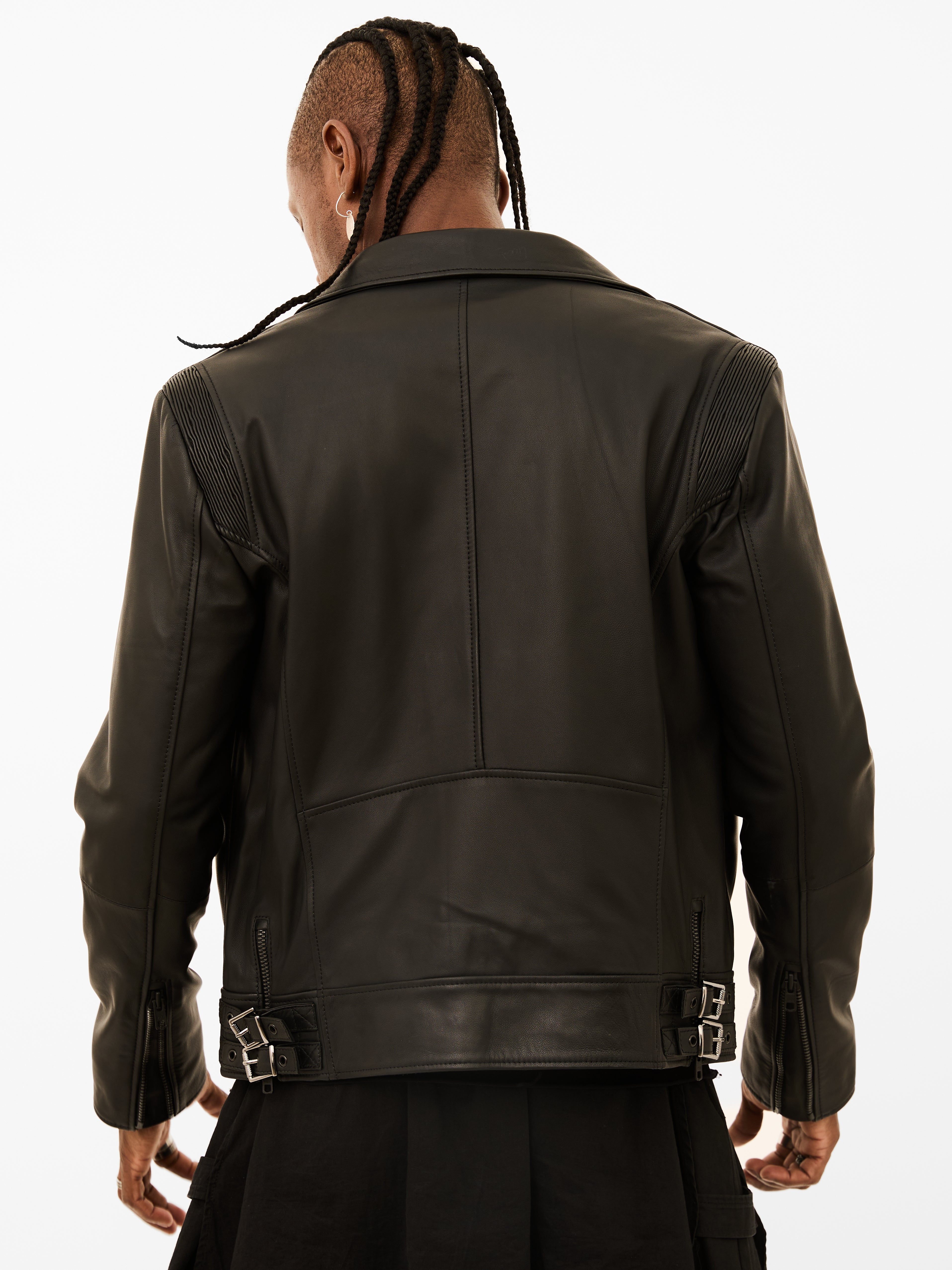 Person wearing a black leather biker jacket on a white background
