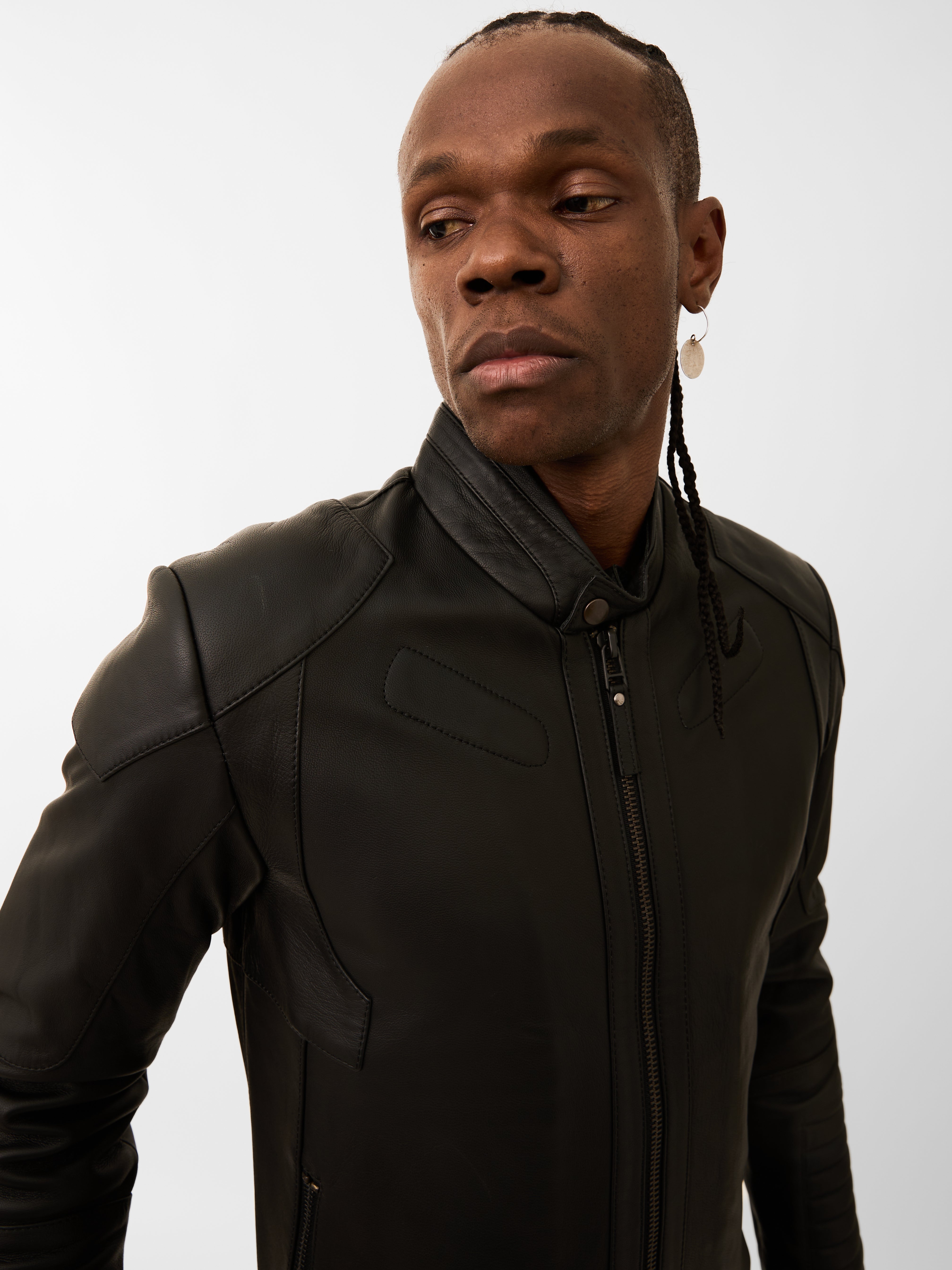 Person wearing a black racer jacket on a plain background
