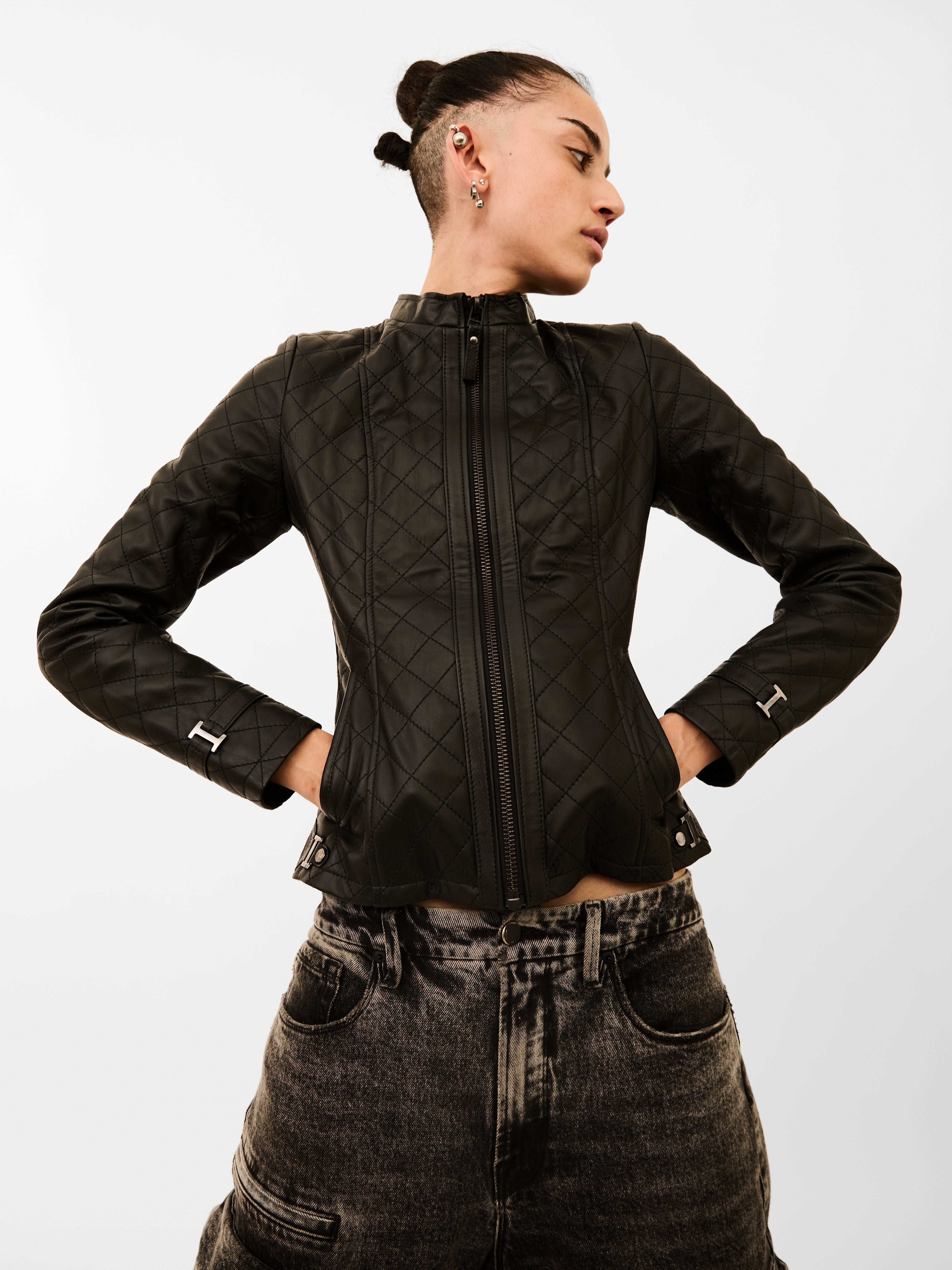 Person wearing a black quilted jacket with a white background