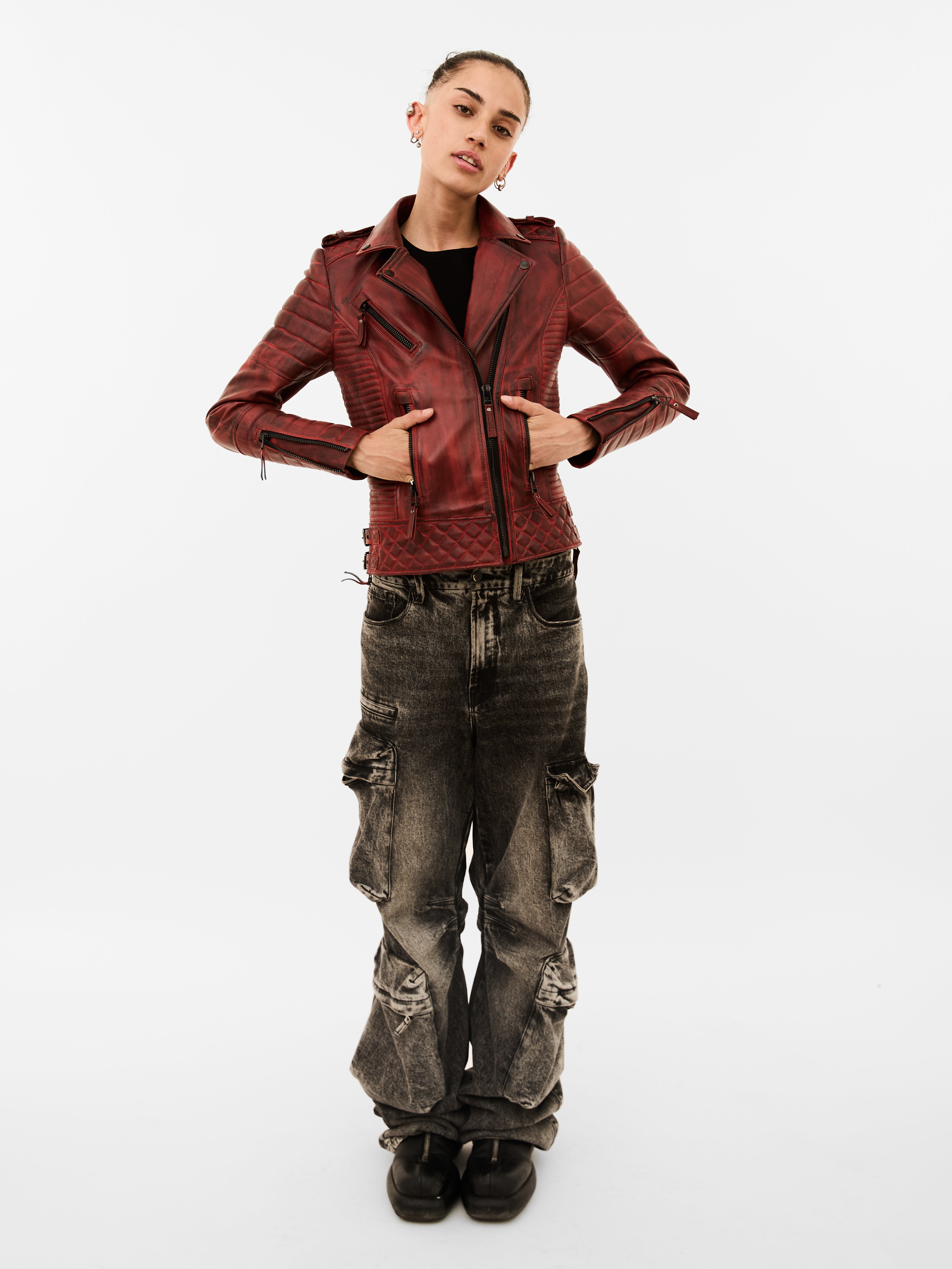 Person wearing a red jacket and dark jeans on a white background