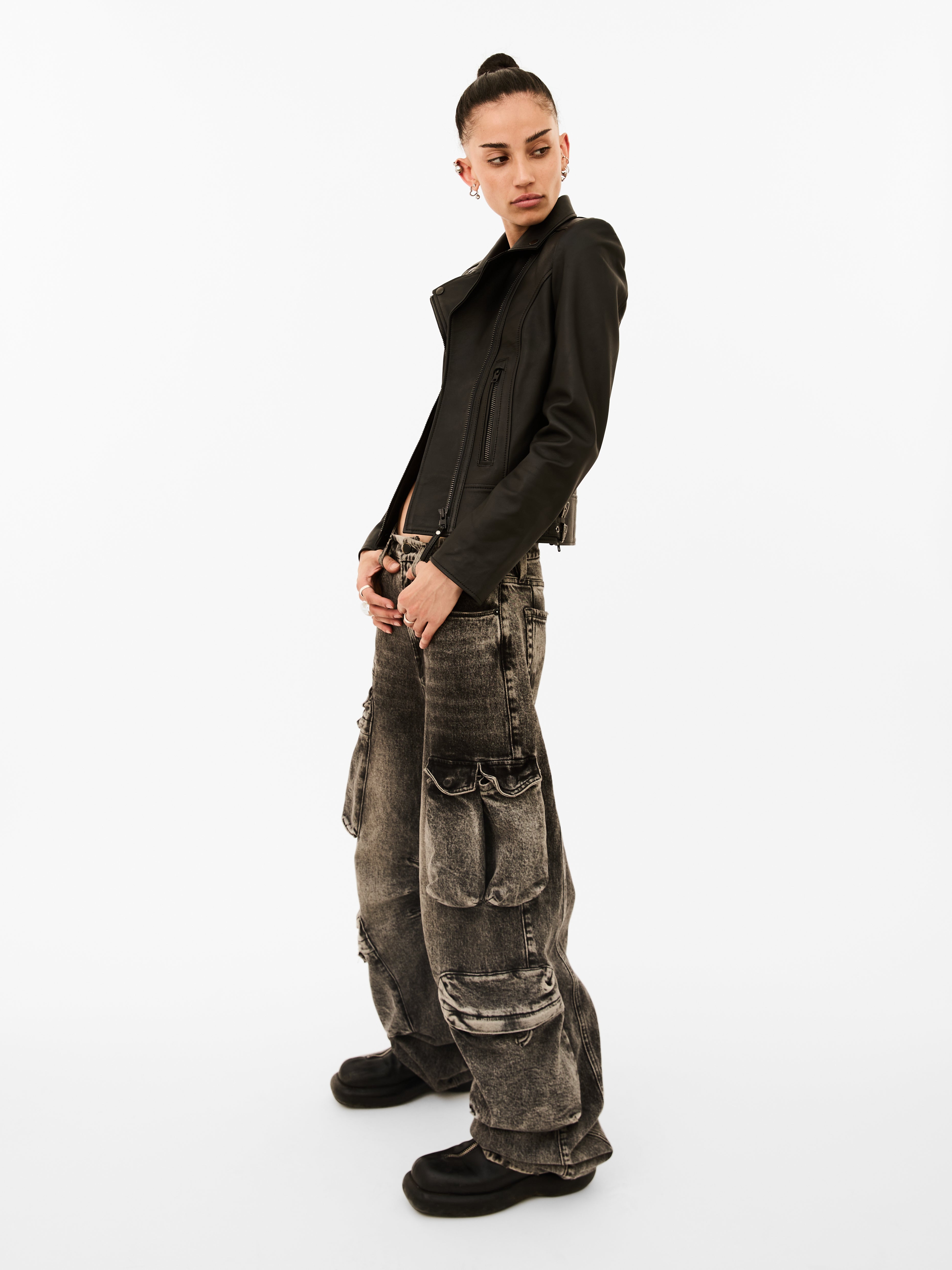 A woman wearing classic black leather biker jacket on a white background
